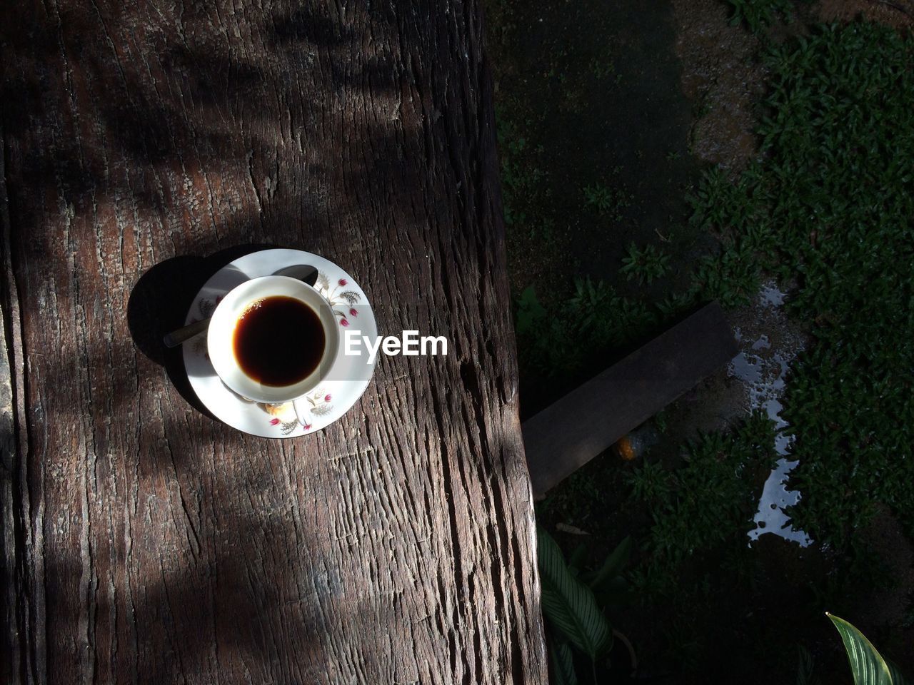 High angle view of coffee cup on wooden table