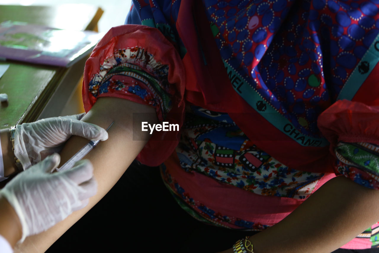 Close-up of woman getting injected by doctor