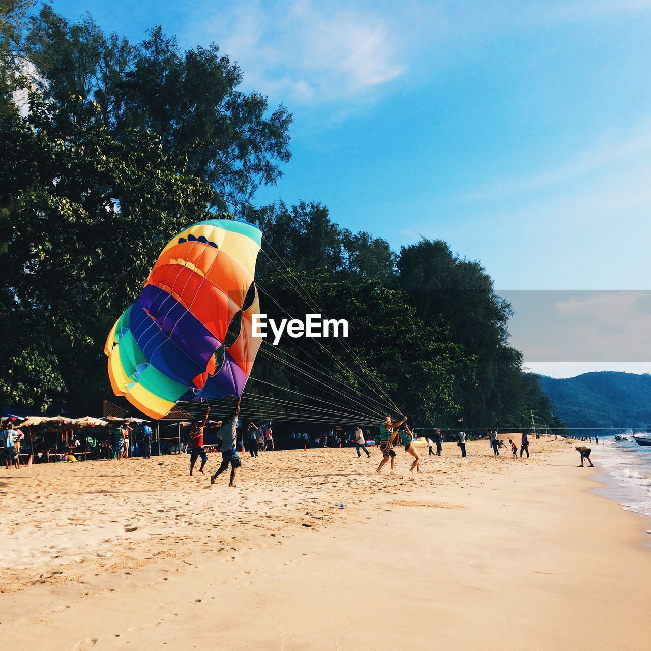 Parasailing on beach against sky