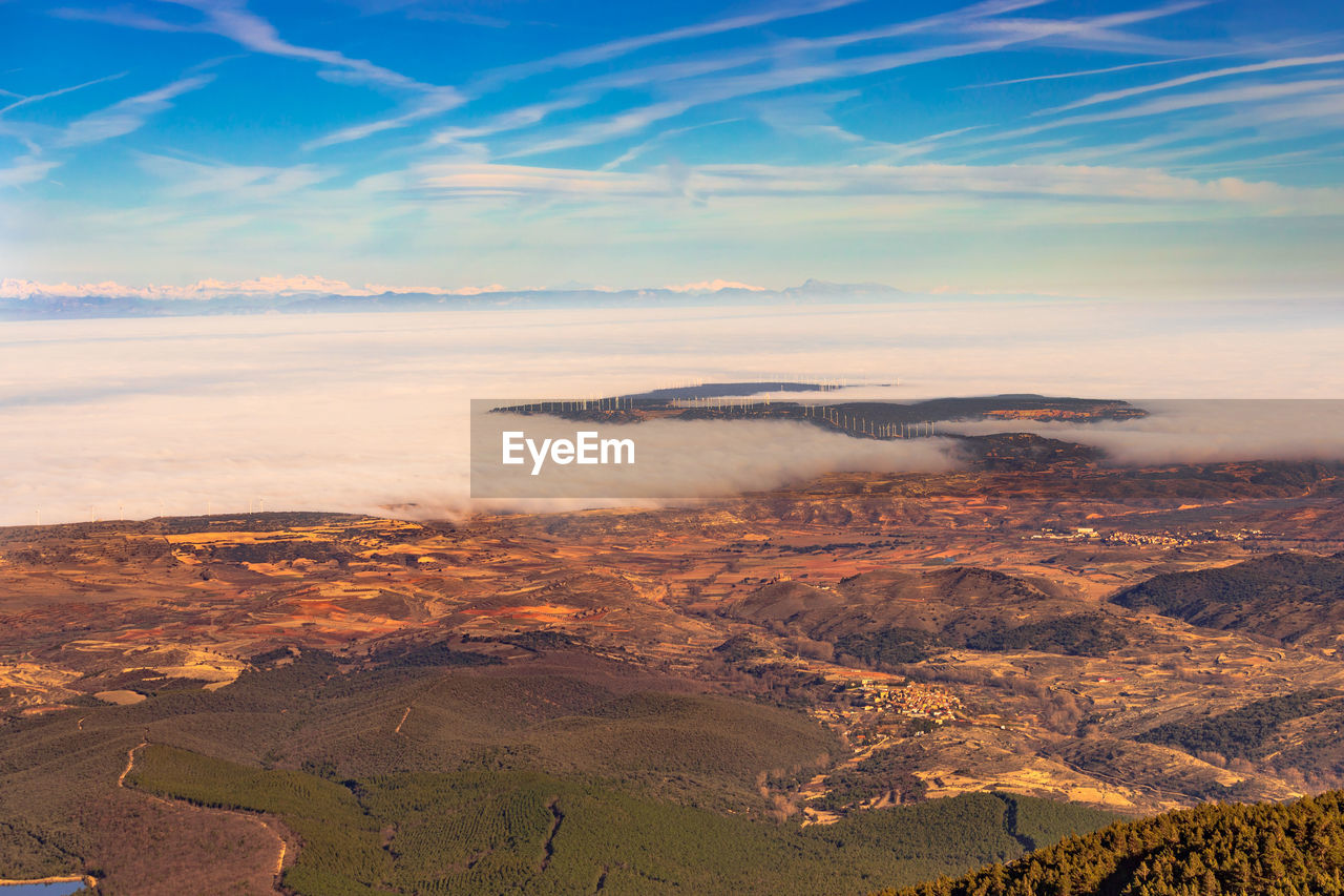 High angle view of cloud-filled valley against mountains and sky during sunset