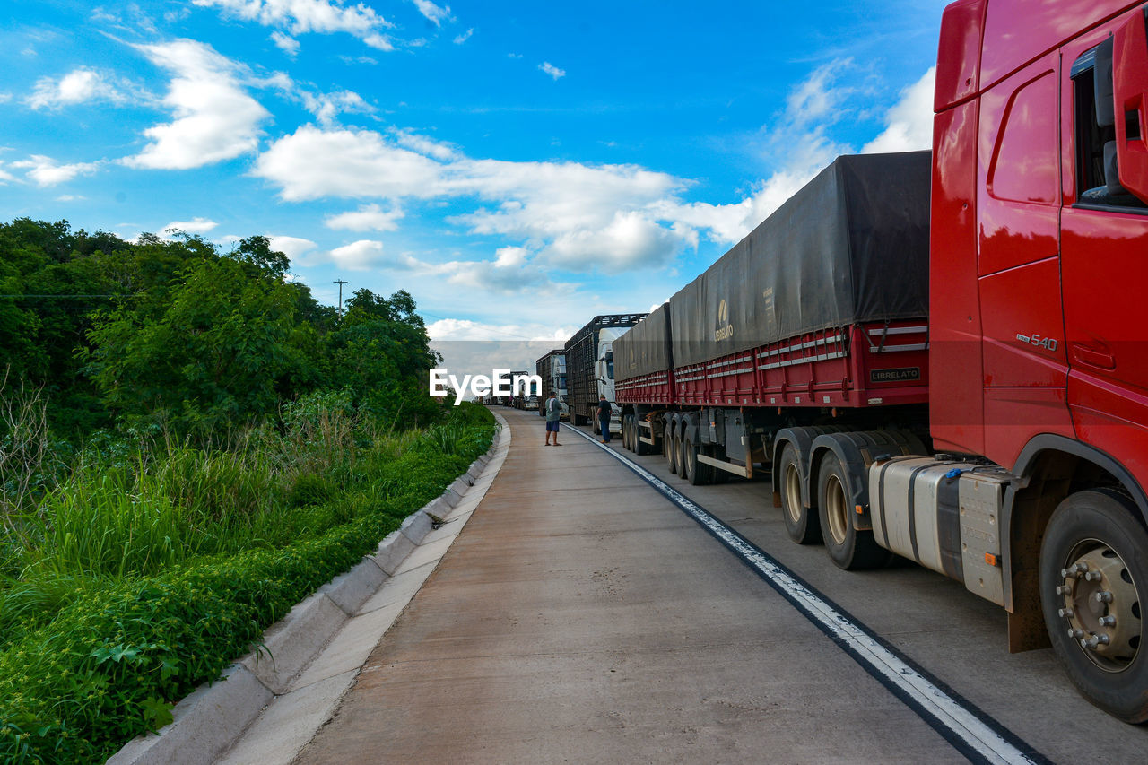 Truck congestion on the highway in the late afternoon and a beautiful blue sky. 