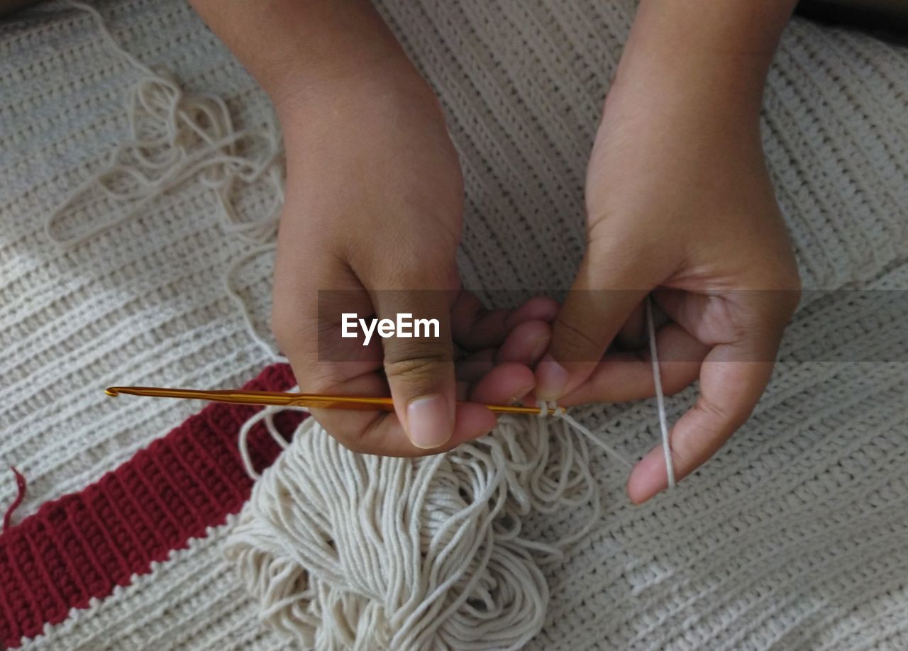 A young girl making knits.