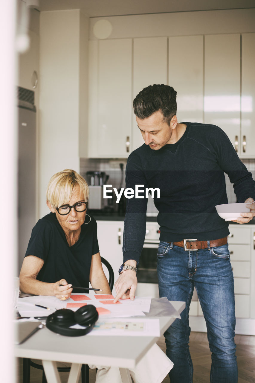 Man and woman discuss blueprint working at home