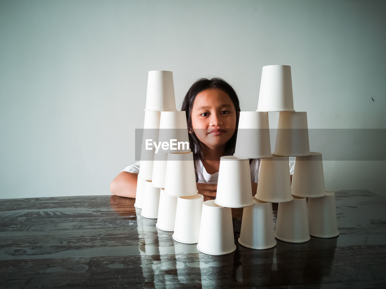 Portrait of smiling girl stacking glasses