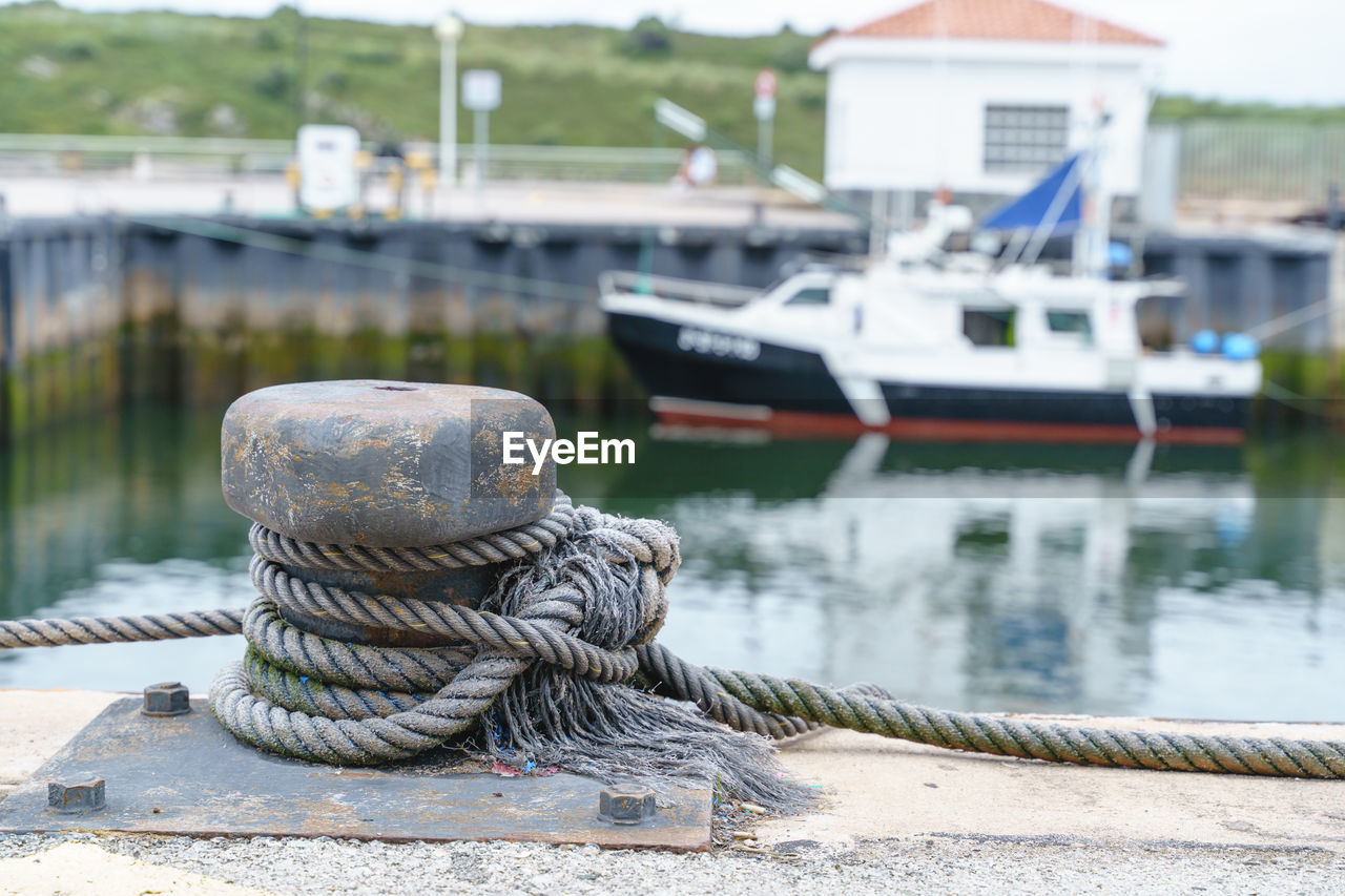 water, nautical vessel, transportation, harbor, rope, mode of transportation, pier, day, focus on foreground, nature, no people, moored, lake, architecture, ship, outdoors, boat, dock, buoy, built structure, post, vehicle, fishing industry, commercial dock, jetty, bollard, beach