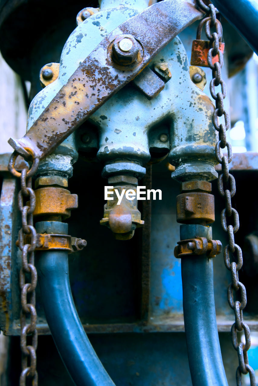 CLOSE-UP OF RUSTY METAL CHAIN AGAINST BLUE SKY