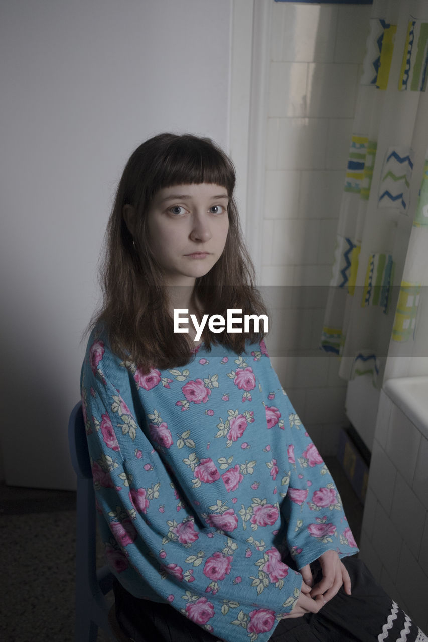 Portrait of young woman sitting at home