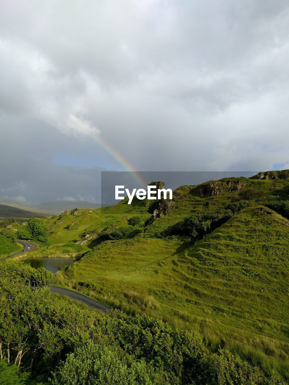 Scenic view of rainbow over land against sky