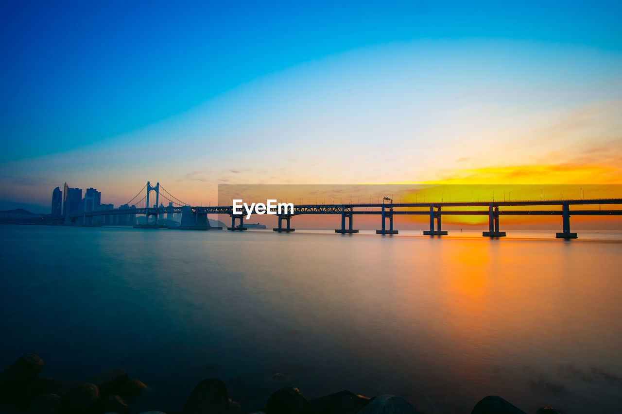 SILHOUETTE OF SUSPENSION BRIDGE IN SEA