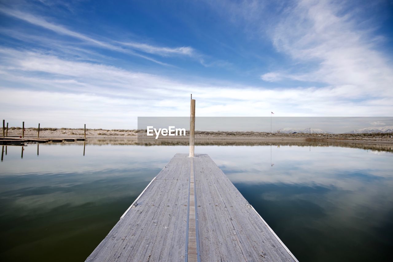 Jetty in lake against sky