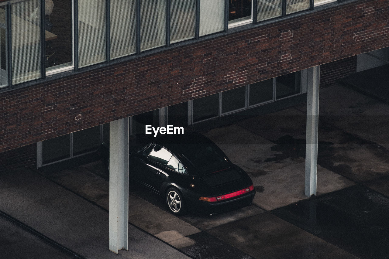 CAR PARKED ON ROAD AGAINST BUILDINGS