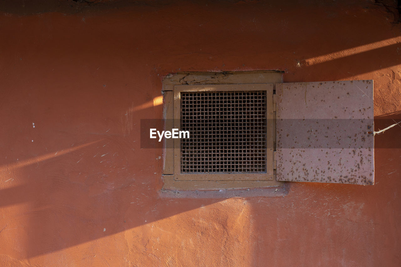 CLOSE-UP OF OLD WINDOW ON WALL