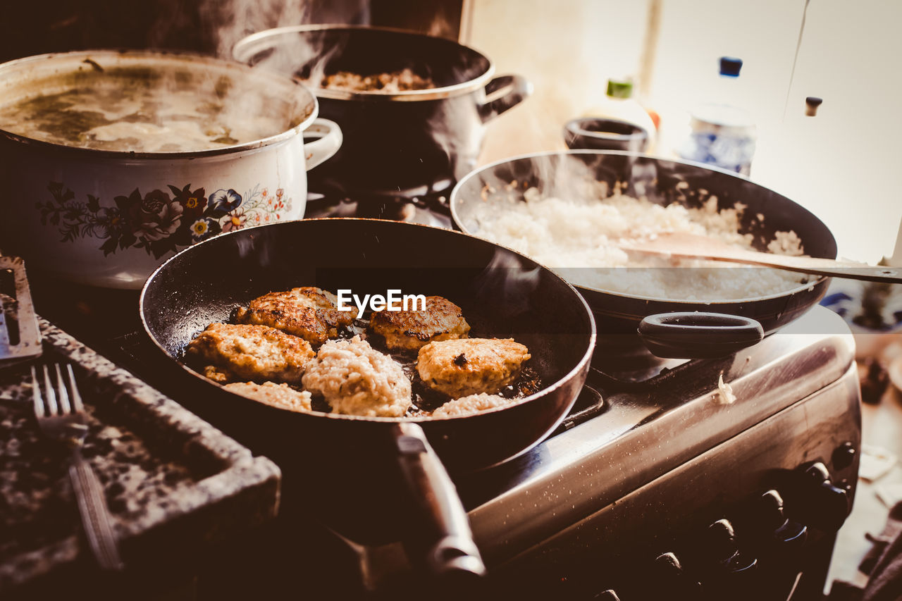 High angle view of food cooking on stoves in kitchen