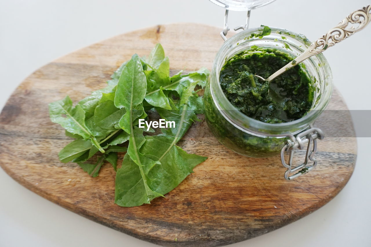 High angle view of dandelion pesto sauce on cutting board against gray background