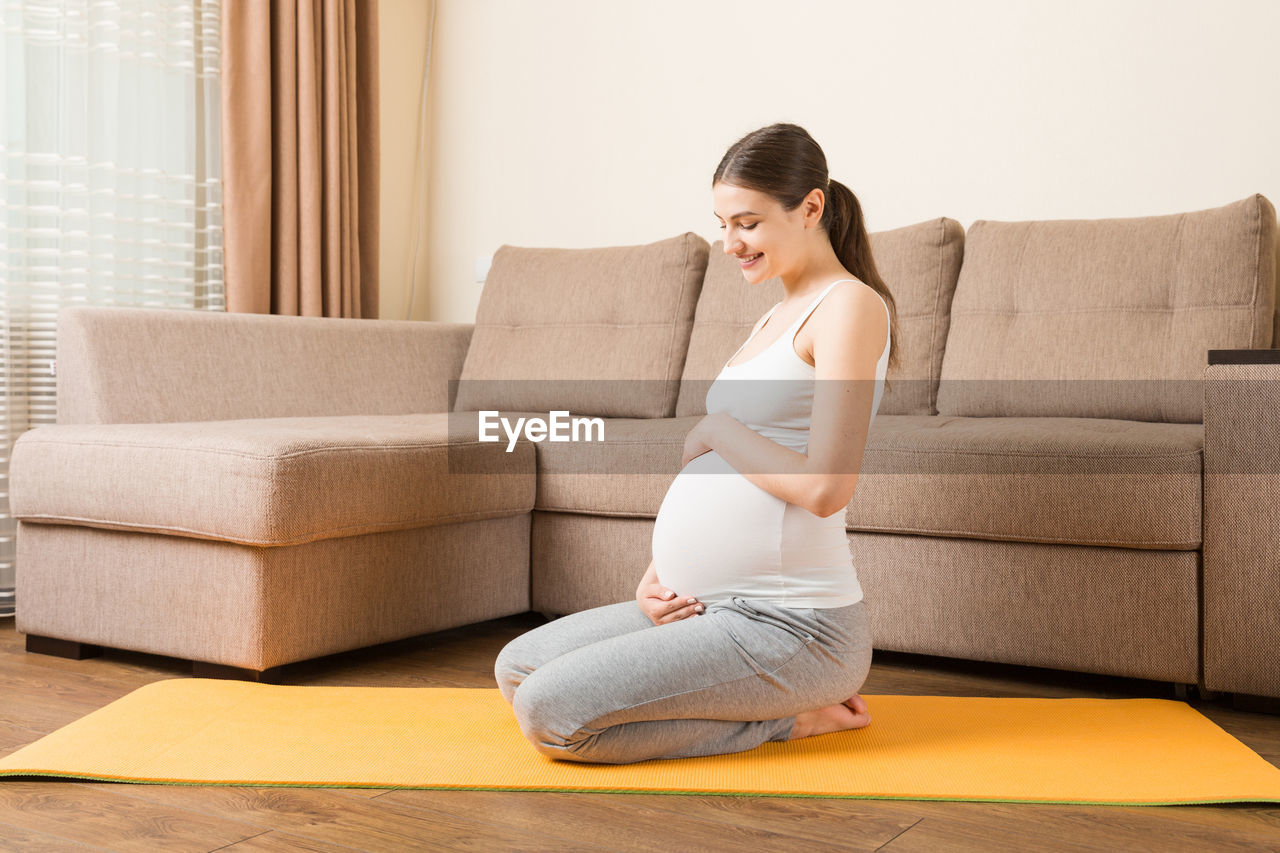 Pregnant woman meditating sitting in yoga position. meditating on maternity pregnancy yoga 