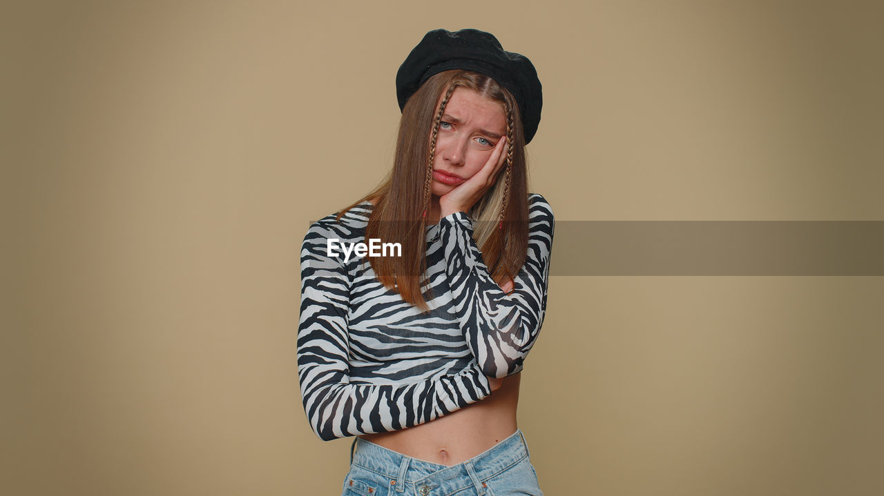 young woman standing against pink background