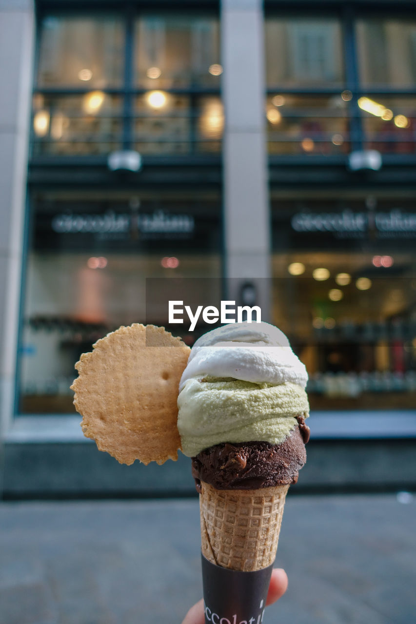 CLOSE-UP OF ICE CREAM CONE AGAINST BLURRED BACKGROUND