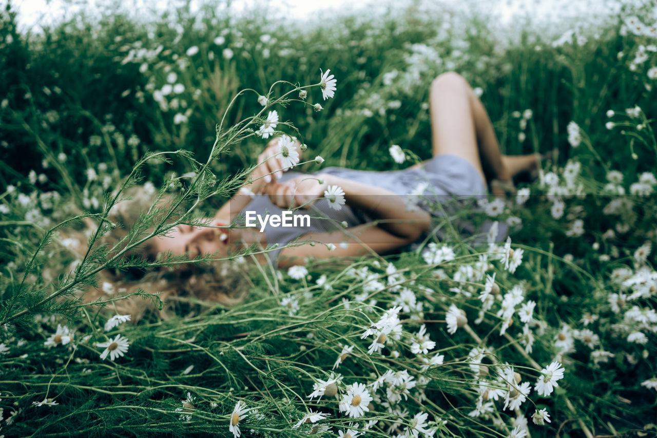 YOUNG WOMAN LYING ON GRASS