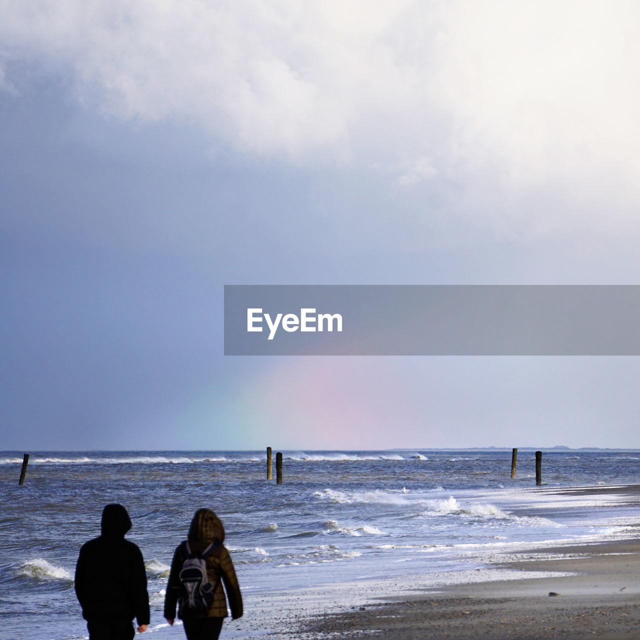 Scenic view of beach against cloudy sky