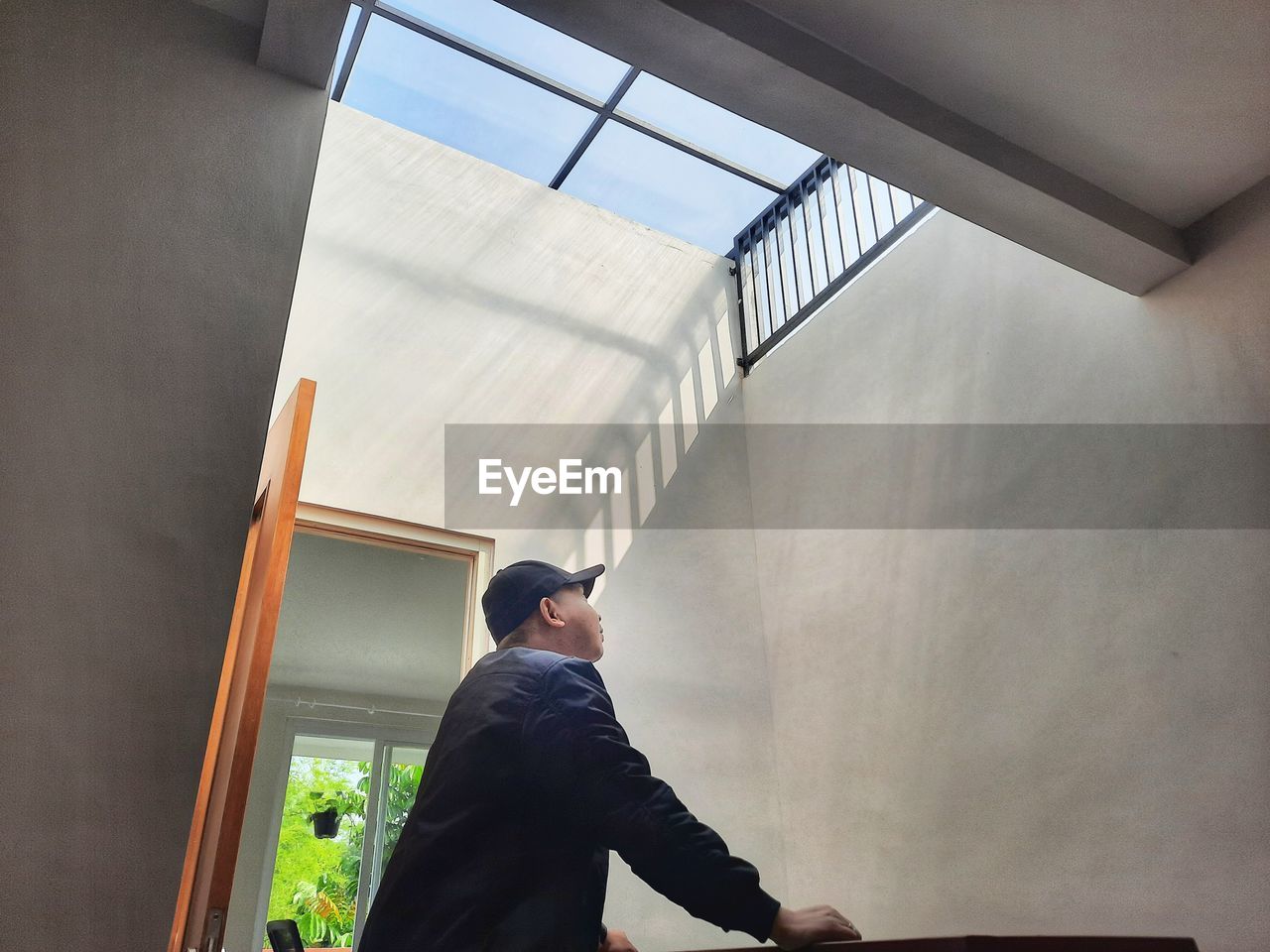 Low angle view of man looking through window
