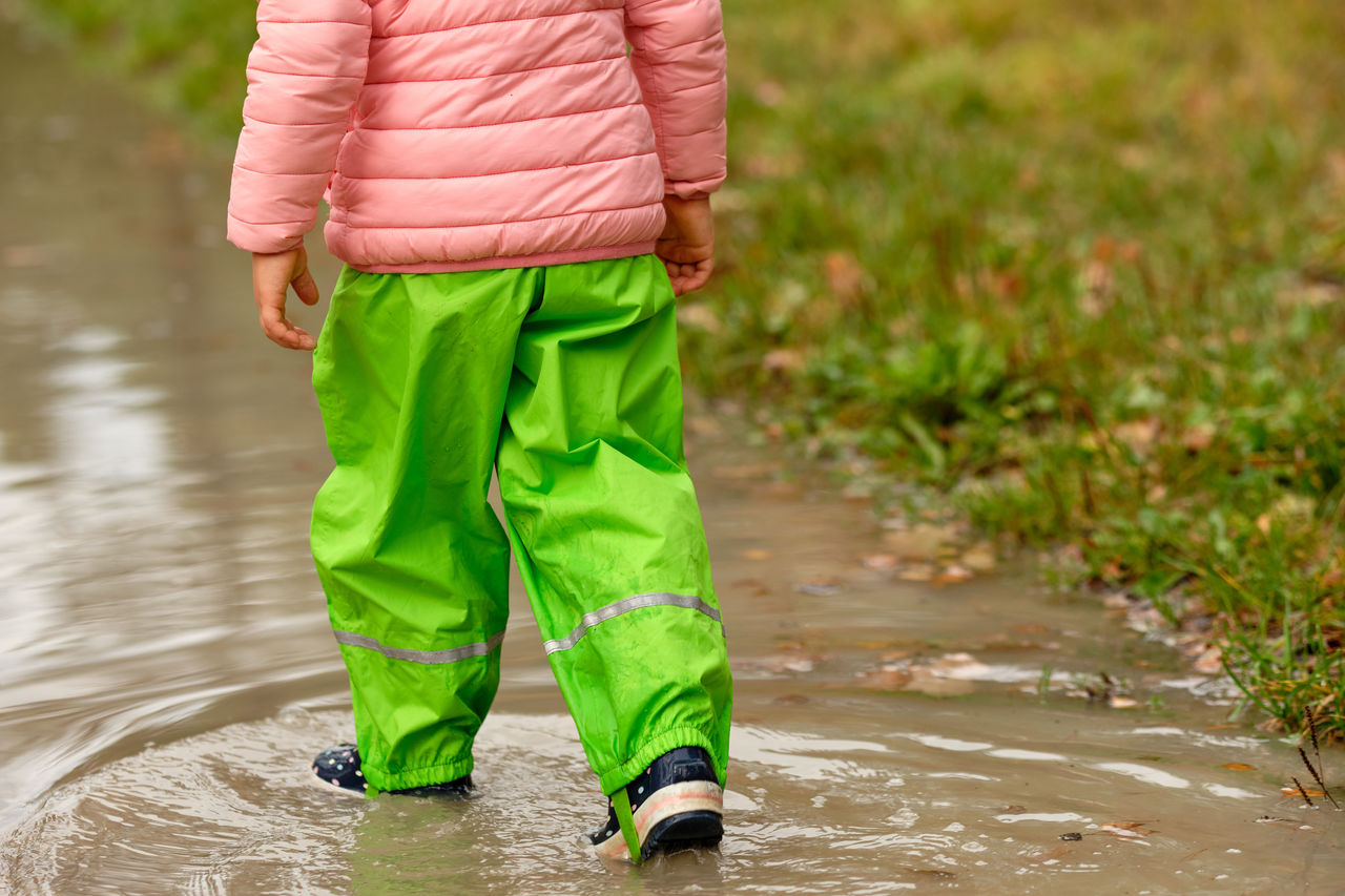 Low section of person walking in puddle