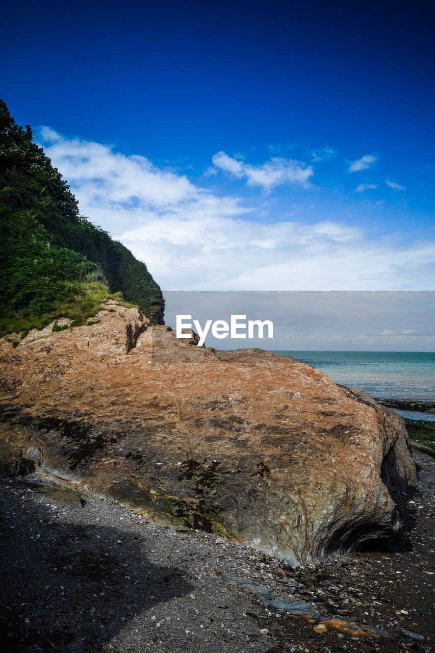 ROCKS ON BEACH AGAINST SKY