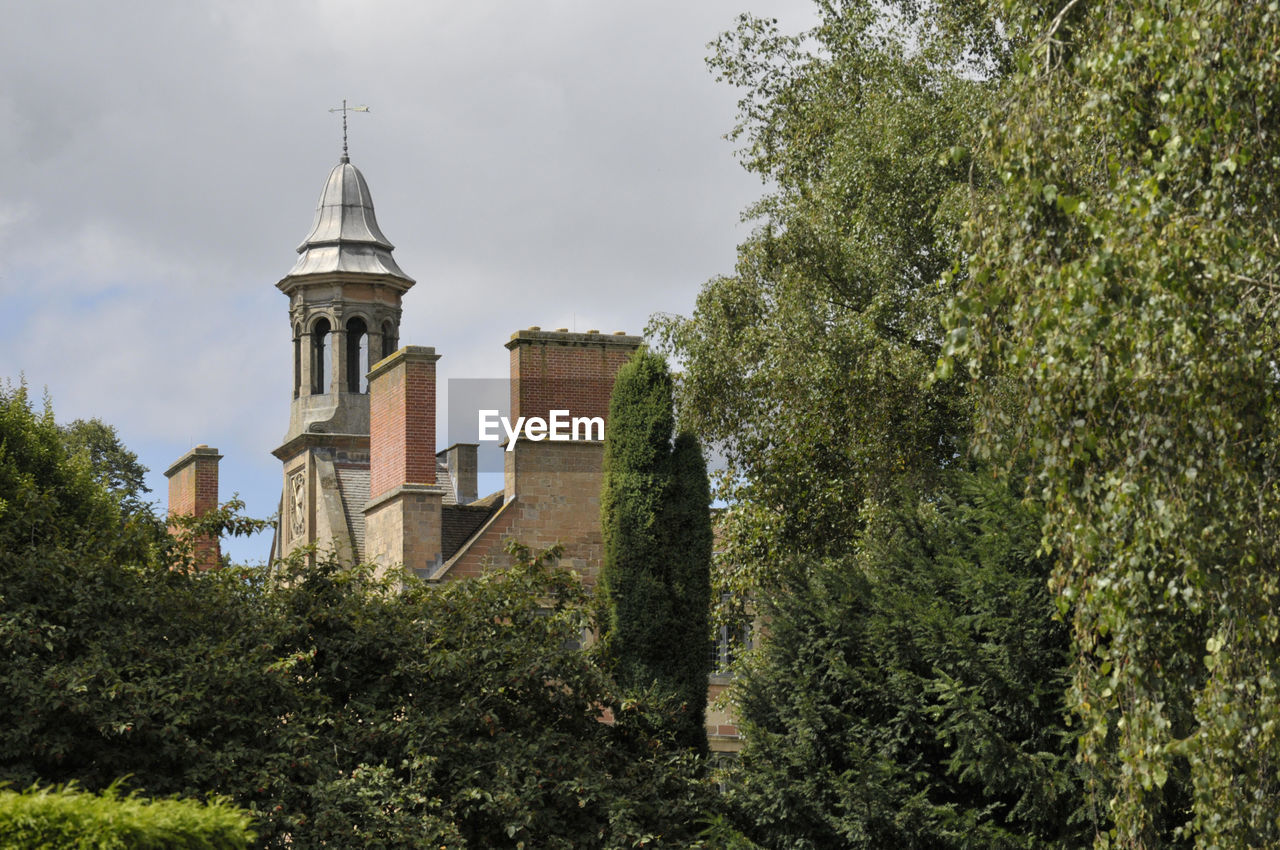 An old bell tower behind trees