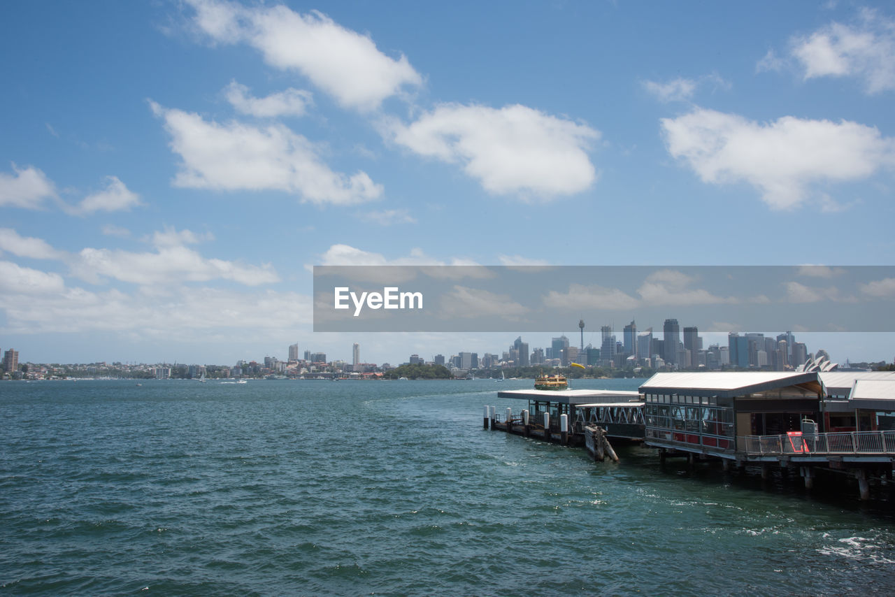 SEA BY BUILDINGS AGAINST SKY IN CITY