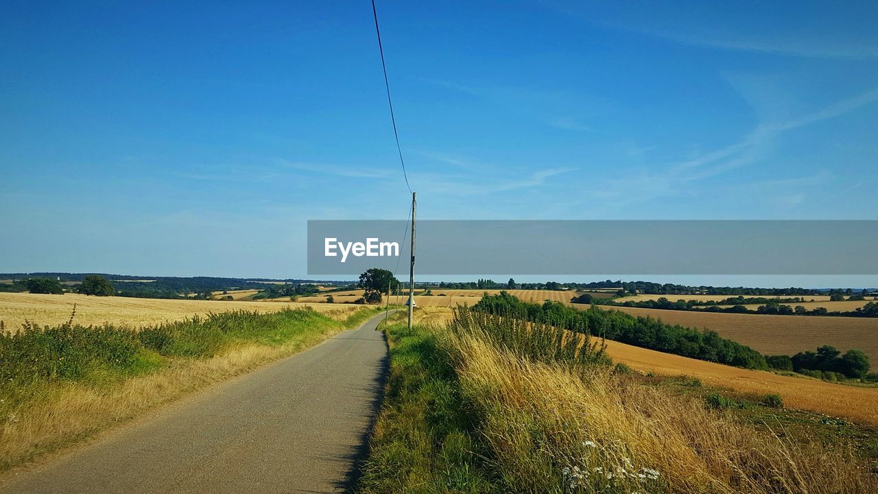 Dirt road passing through field