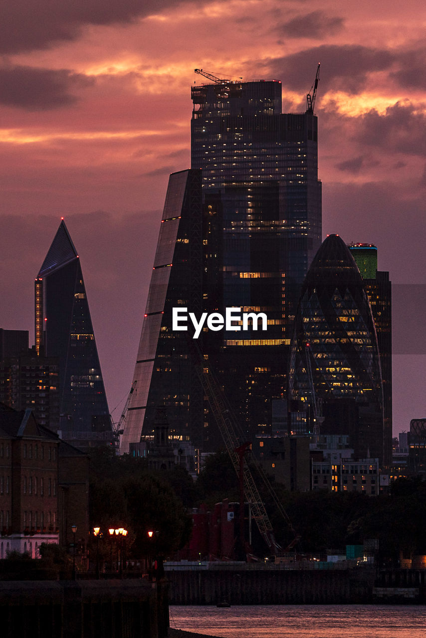 ILLUMINATED MODERN BUILDINGS AGAINST SKY AT SUNSET