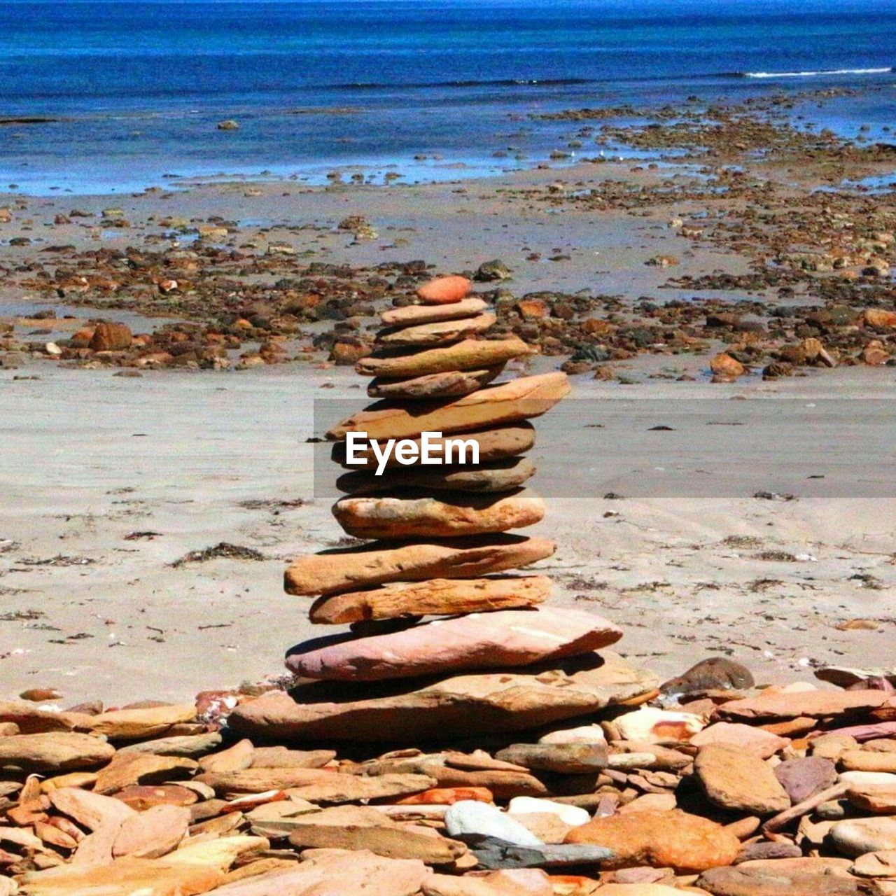 Stack of stones on rocks by sea