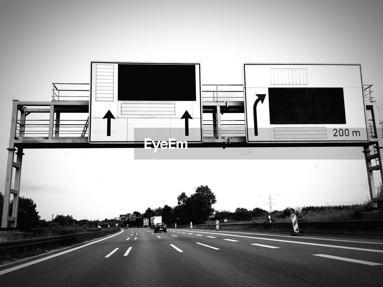 Directional signs above highway against clear sky