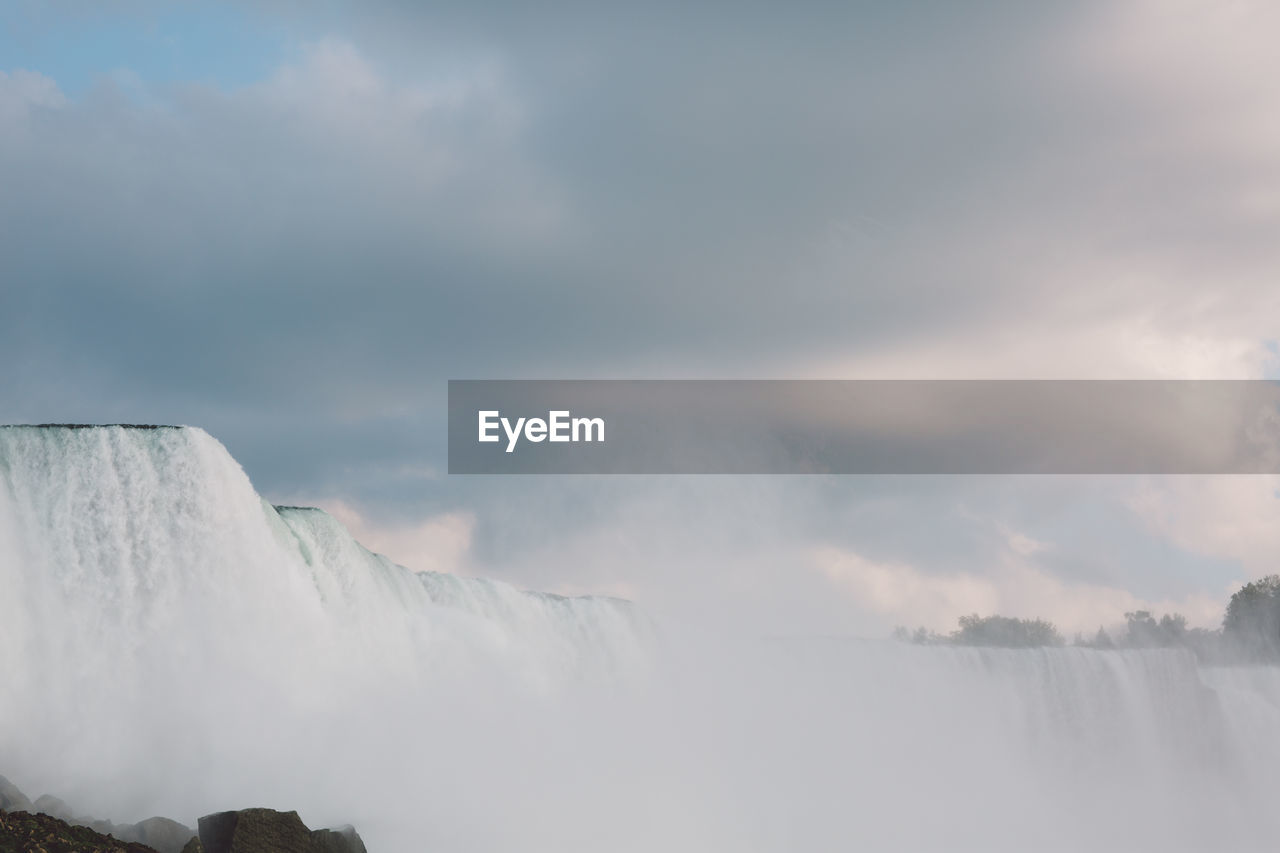 Scenic view of waterfall against sky