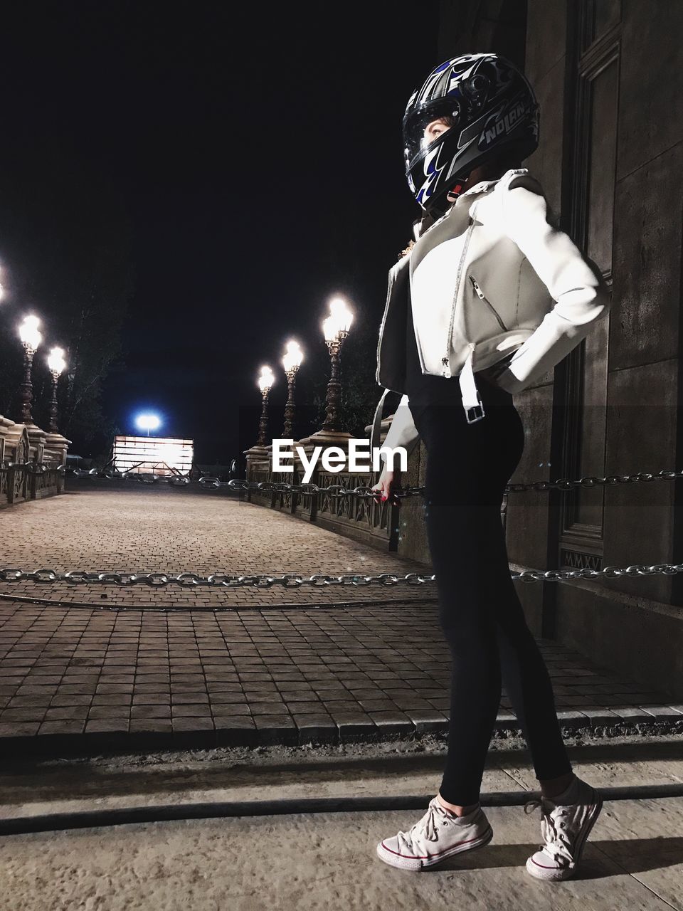 FULL LENGTH OF MAN STANDING ON ILLUMINATED STREET LIGHT