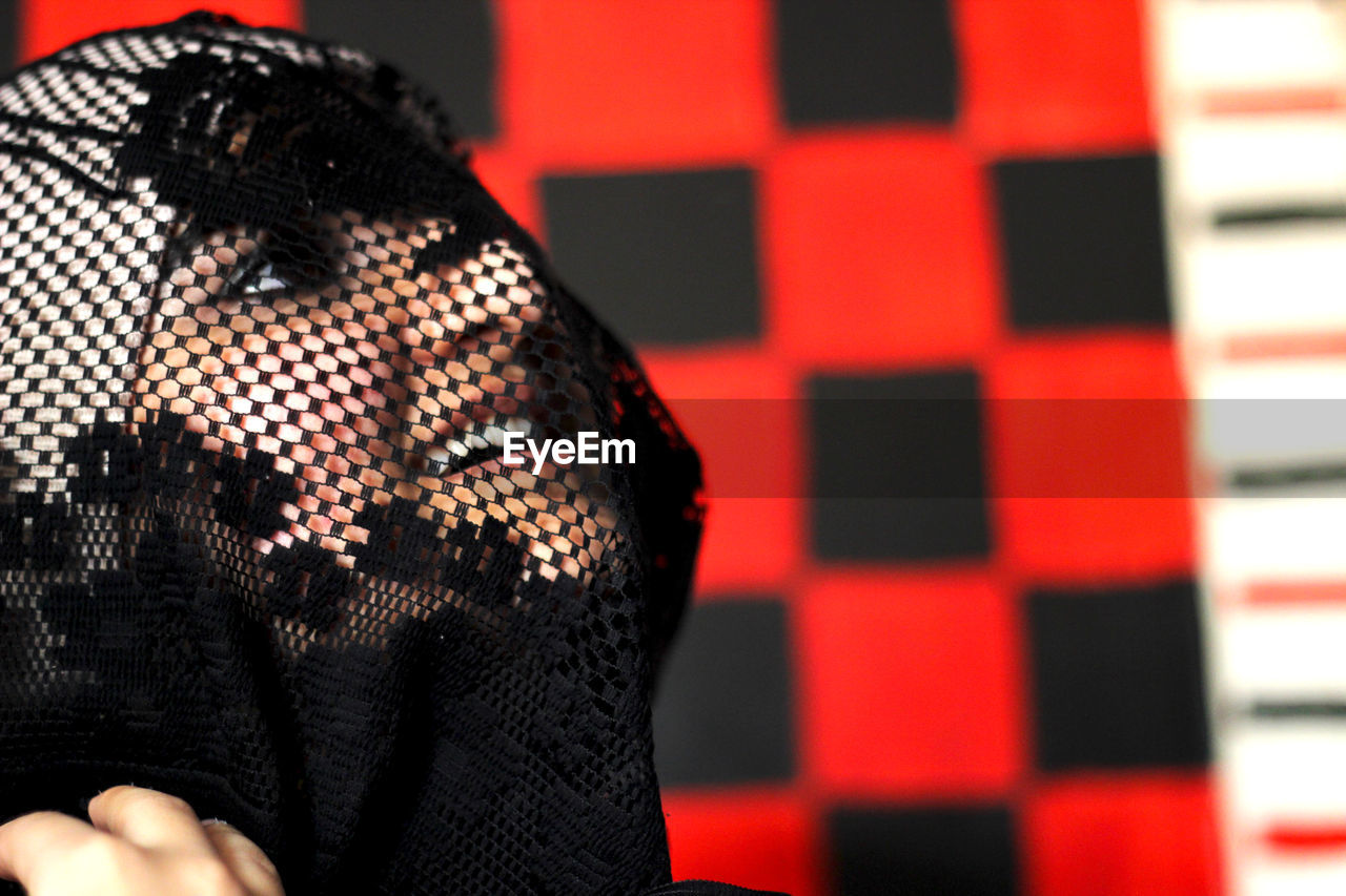 Close-up of woman covering face with scarf