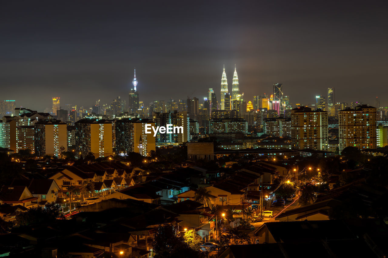 ILLUMINATED CITYSCAPE AGAINST SKY