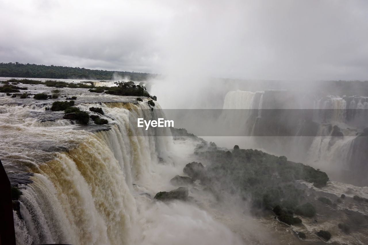 Scenic view of waterfall against sky