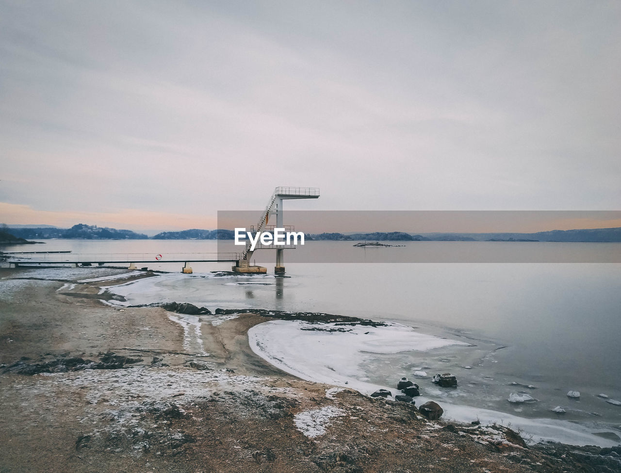 VIEW OF FROZEN SEA AGAINST SKY DURING WINTER