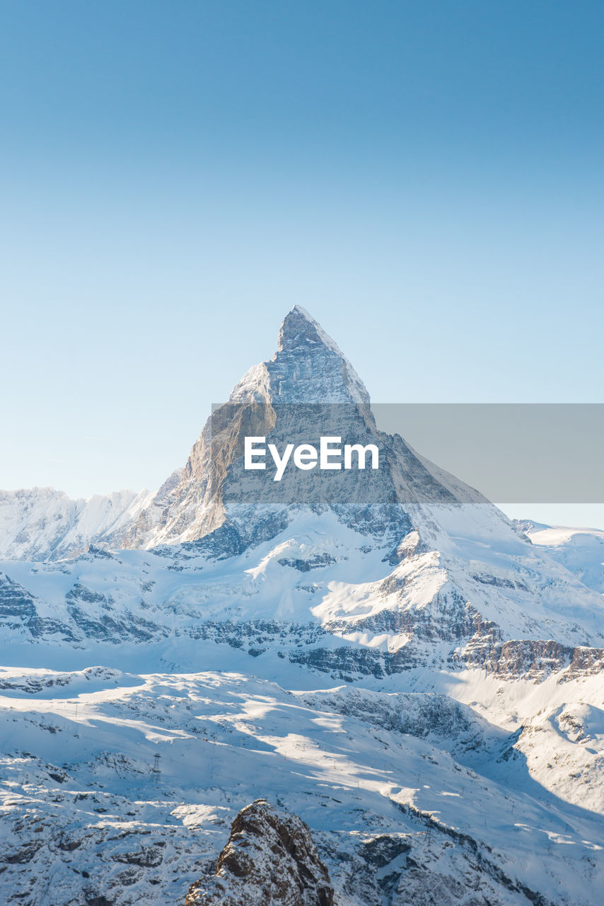 Scenic view of snowcapped mountains against clear sky