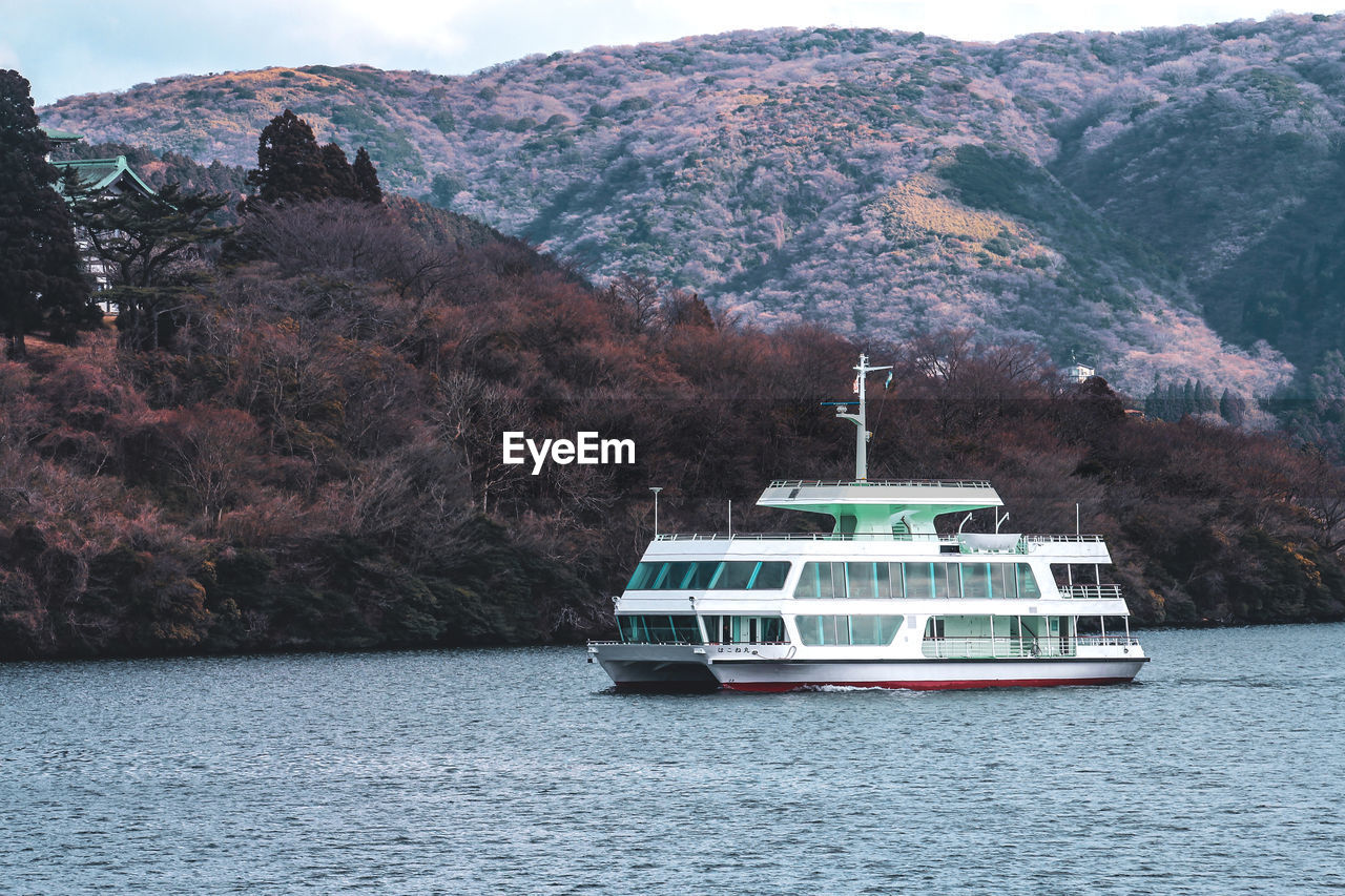 Nautical vessel on sea against mountains