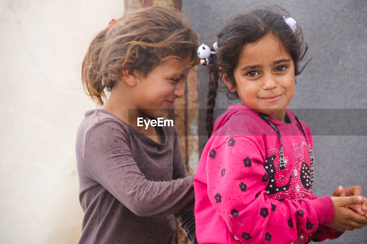 Cute syrian children in a refugee camp in the rain.