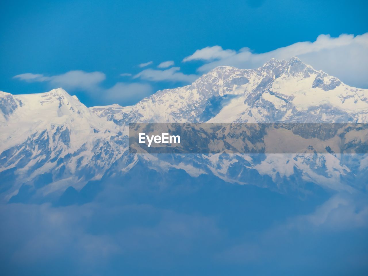 Scenic view of snow mountains against blue sky