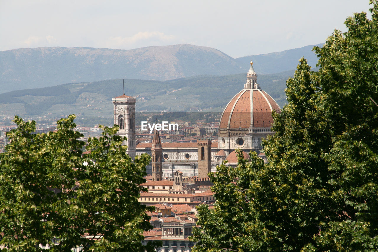 Cathedral in city against mountains