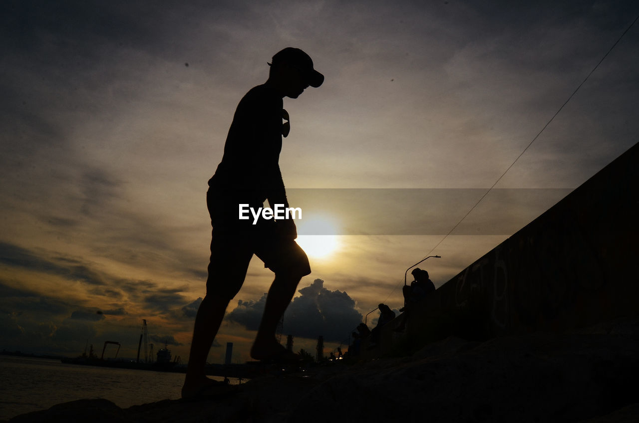 SILHOUETTE MAN STANDING AGAINST SKY DURING SUNSET