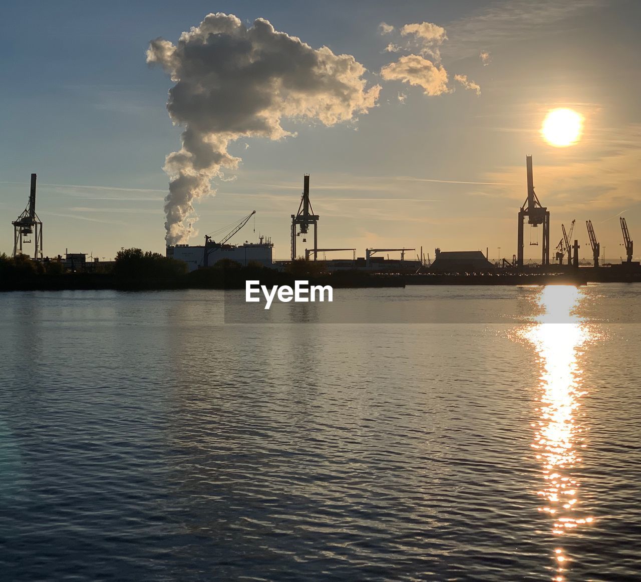 VIEW OF FACTORY BY SEA AGAINST SKY