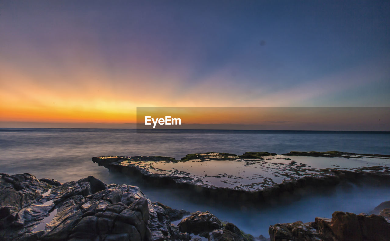 Scenic view of sea against sky at sunset