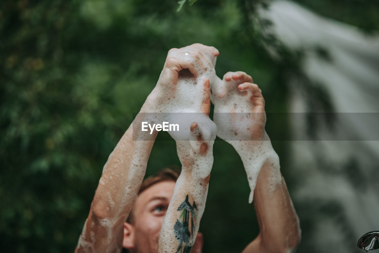 Close-up of man hand on wet outdoors