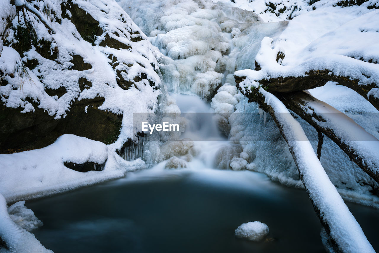 High angle view of waterfall amidst frozen forest