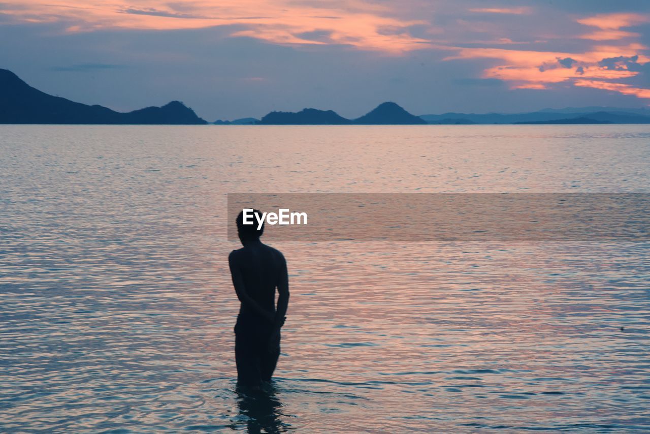 SILHOUETTE MAN STANDING IN SEA AGAINST SKY