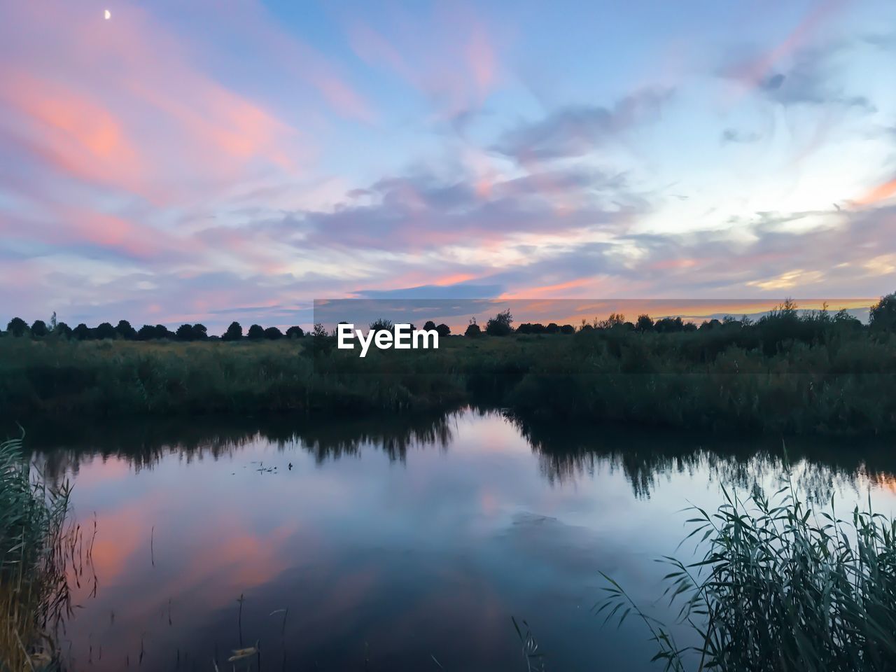 SCENIC VIEW OF LAKE AGAINST ORANGE SKY